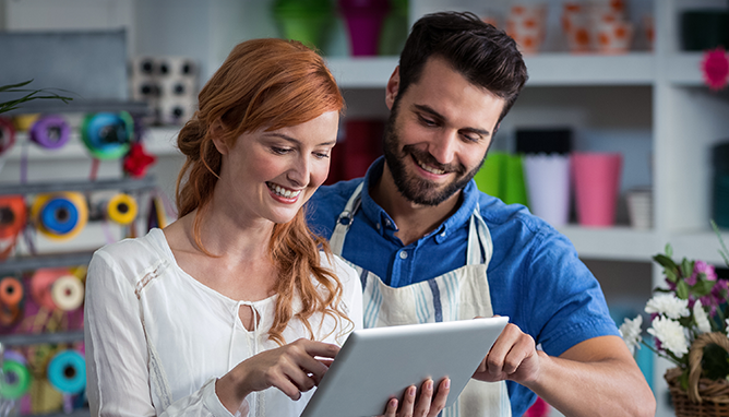 Man and a woman in a store looking at an ipad