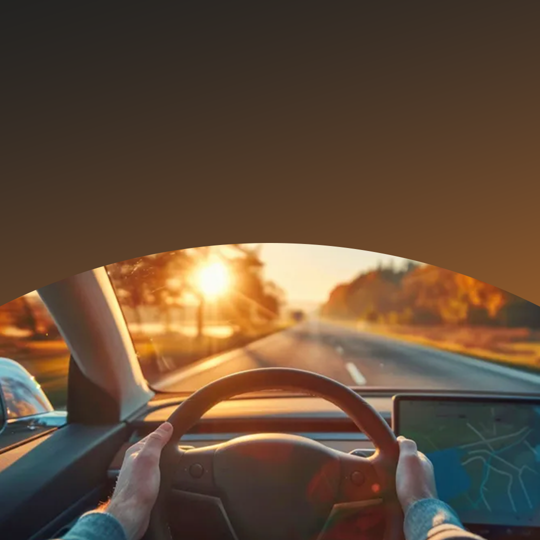 Les mains sur le volant, conduisant au coucher du soleil.