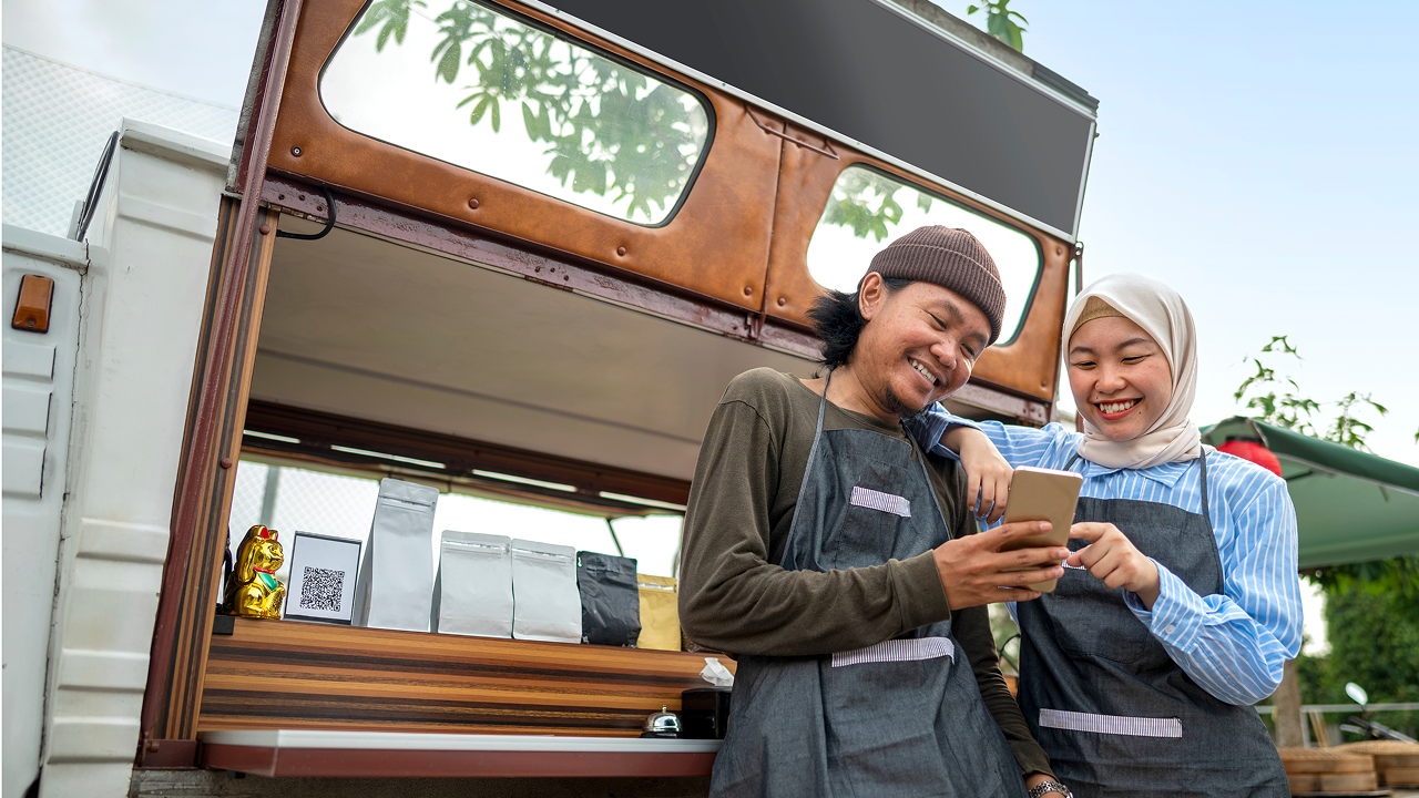 Two people on phone outside of food truck