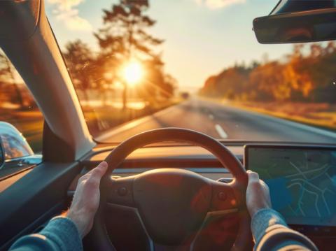 La perspective d'un conducteur regardant une autoroute vers le coucher du soleil, symbolisant les perspectives économiques tournées vers l'avenir pour 2025.