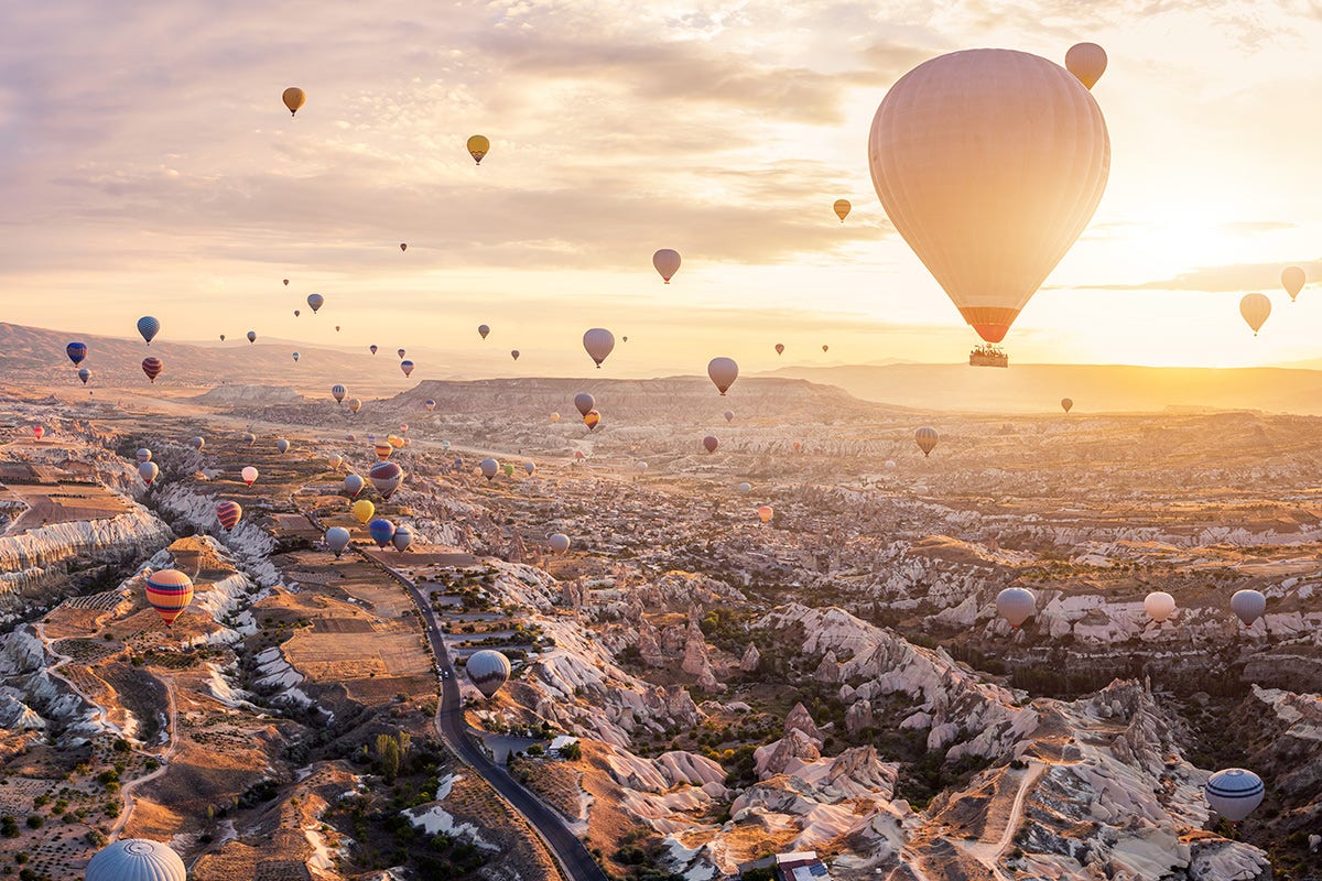 View of many hot air balloons lifting into the sky.