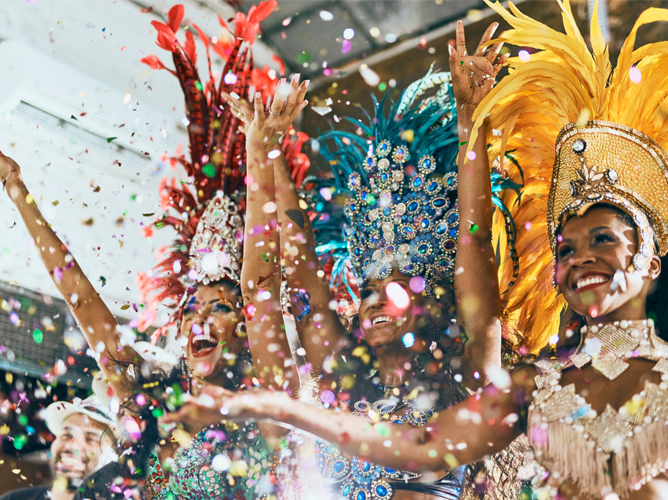 Des danseurs de samba exultants vêtus de costumes de carnaval étincellants ornés de plumes célèbrent alors que des confettis tombent, capturant l'énergie vibrante d'une parade ou d'un festival.