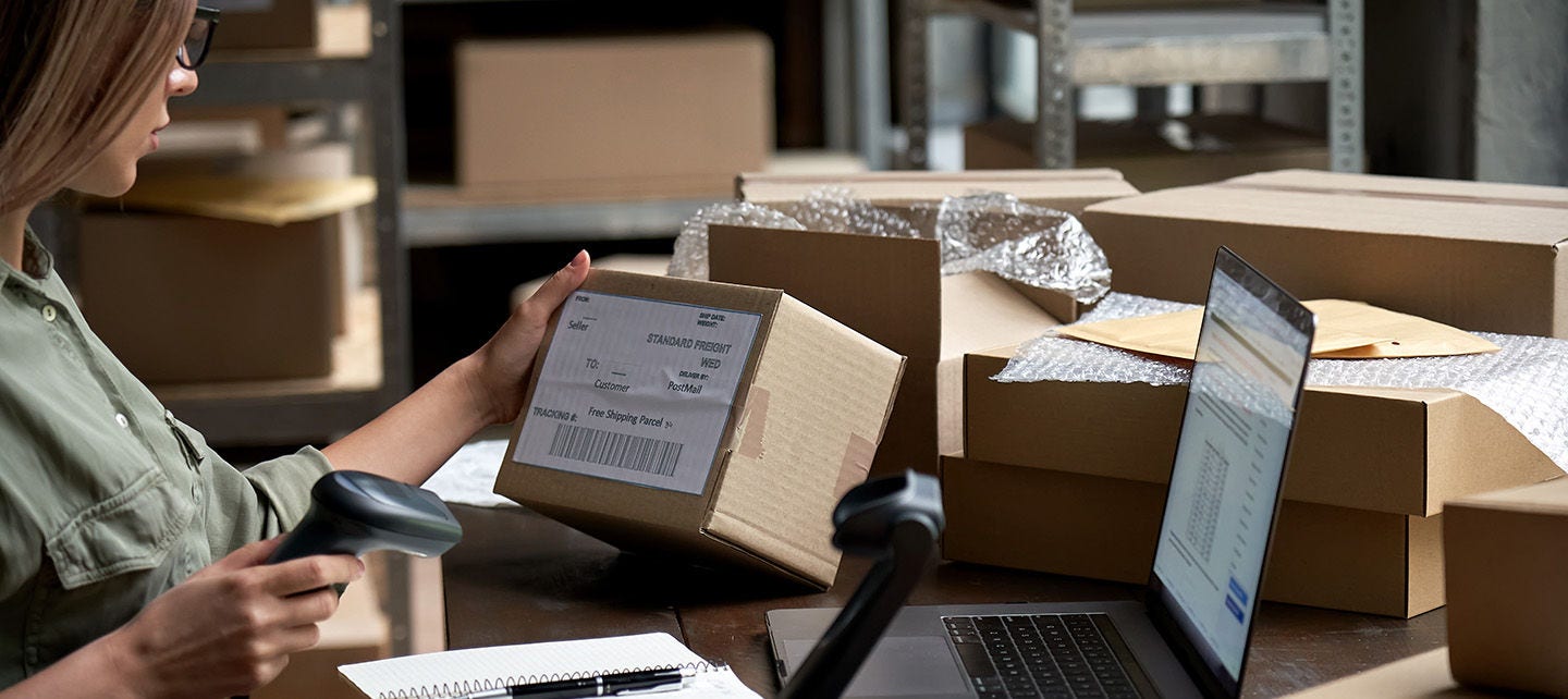 Woman scanning shipping boxes