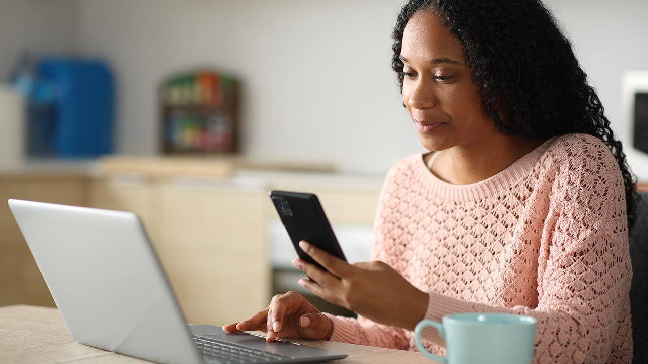 Mujer usando dos dispositivos en la oficina en casa.