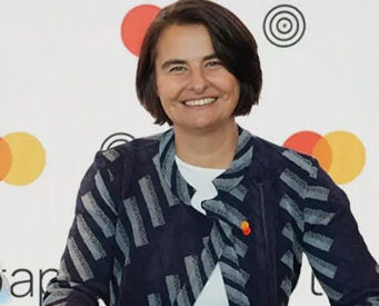 Woman smiling with Mastercard background.