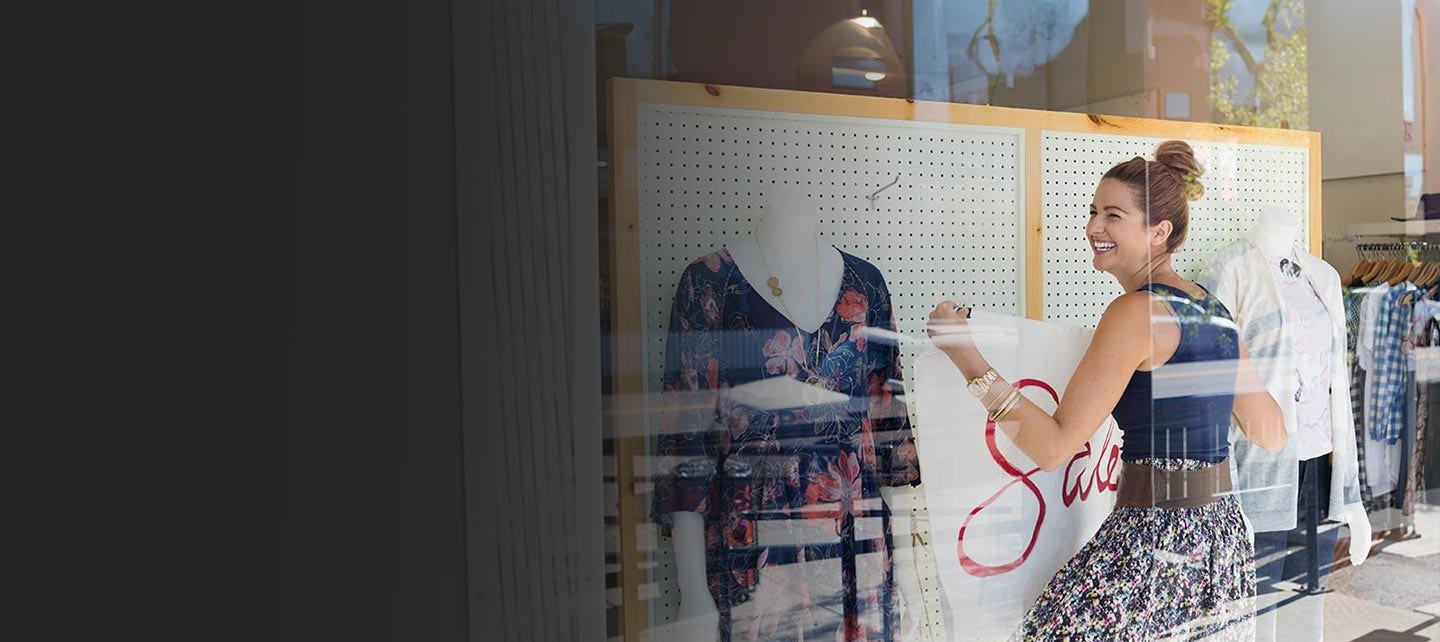 Shop owner decorating a front window.