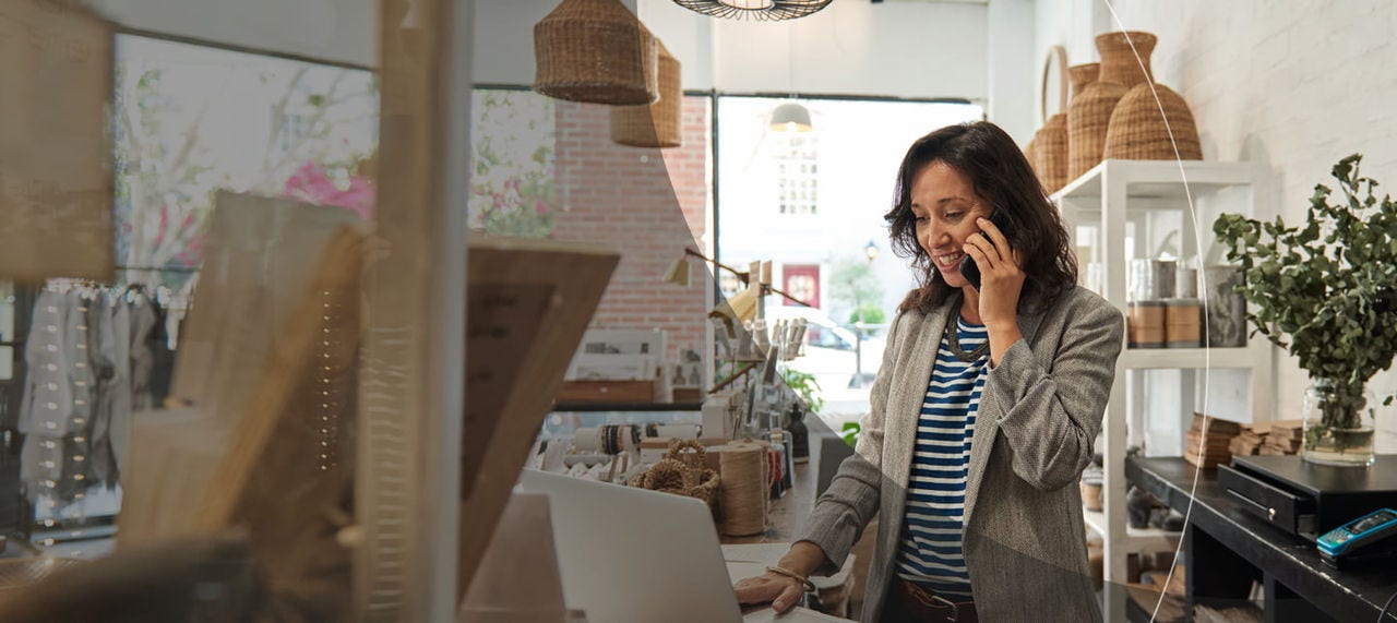 smiling businesswoman using laptop in a boutique