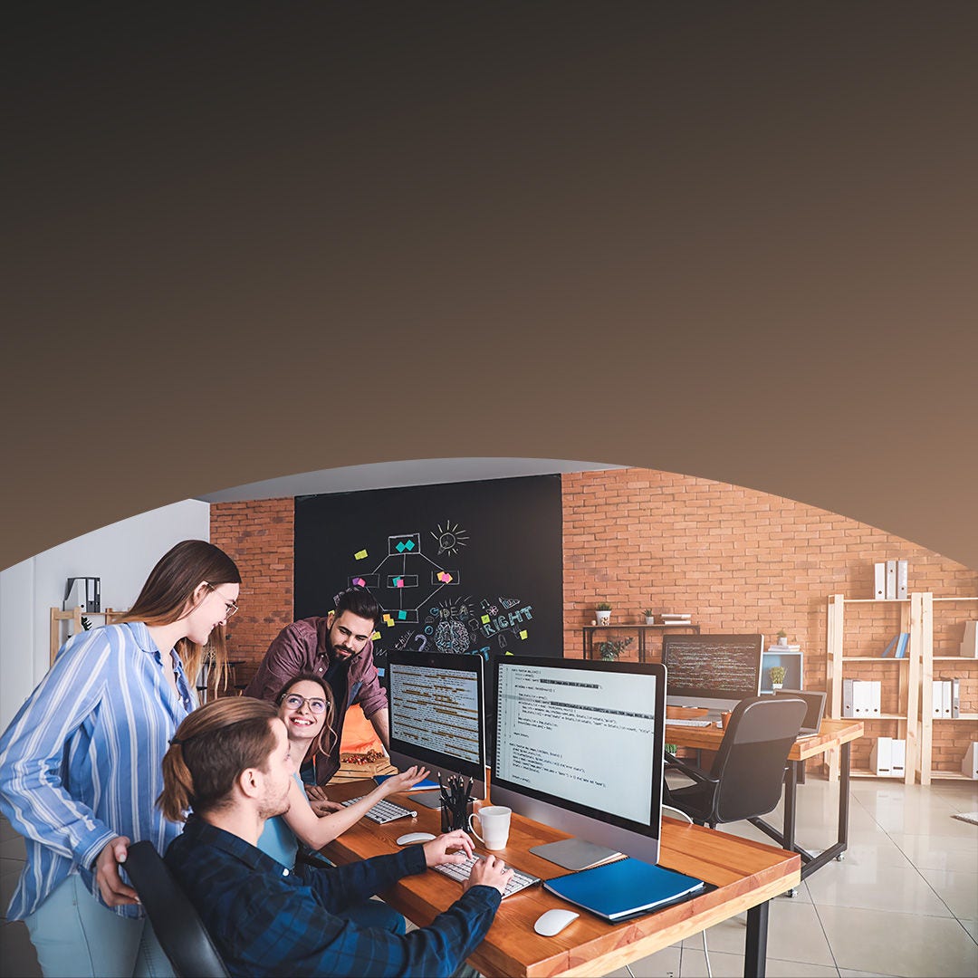 Colegas de trabajo colaborando alrededor de un escritorio y una computadora. 