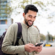 joven árabe sonriente usando tu teléfono.