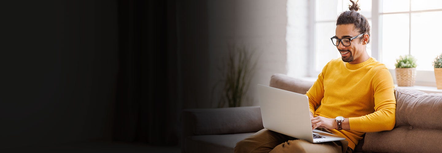 Man on his laptop at home on his couch