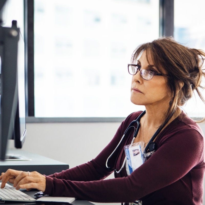 A doctor looks at a computer screen. 