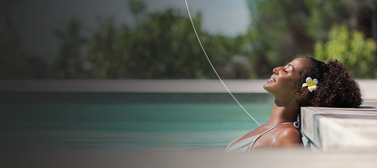 Woman relaxing in luxurious pool.