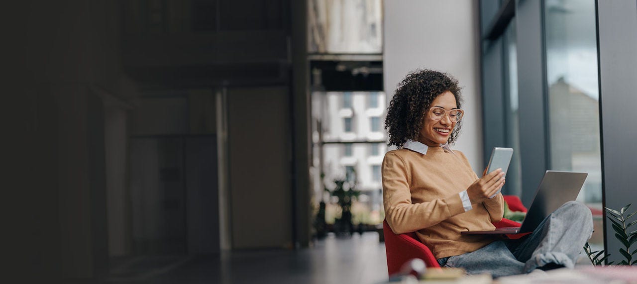 Femme utilisant des appareils dans un bureau moderne.