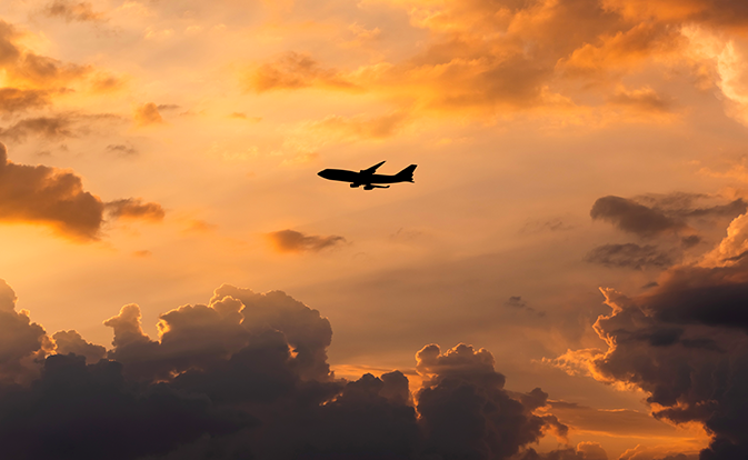 plane flying in sunset