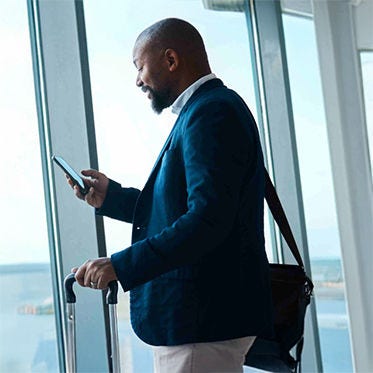 Un homme utilise son smartphone dans le terminal d'un aéroport.