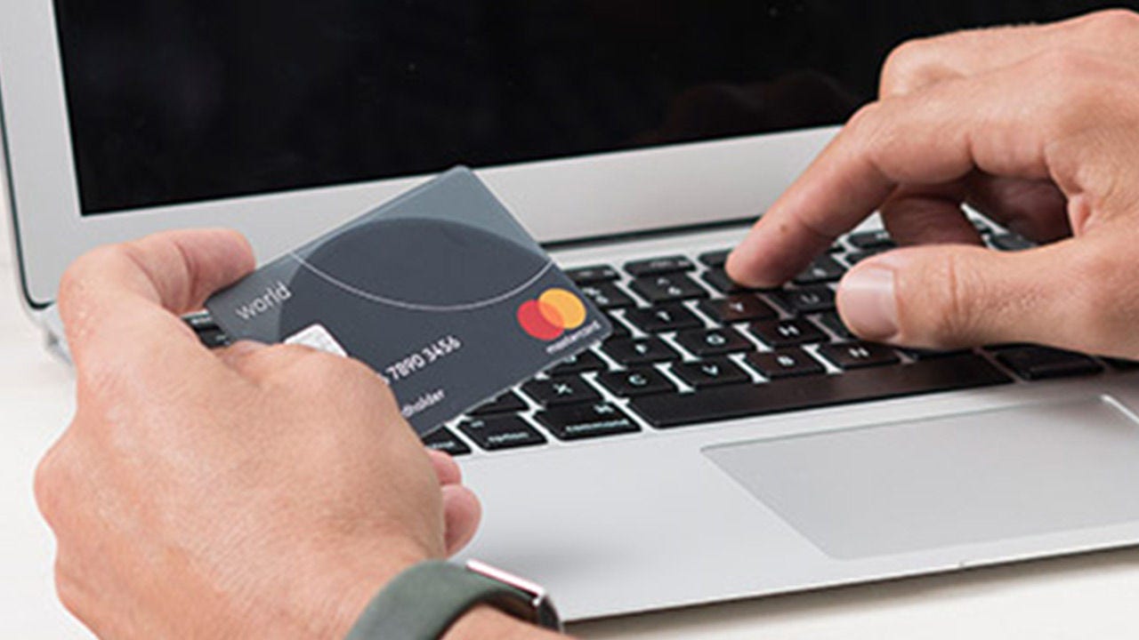 Hombre comprando en línea con World Mastercard.