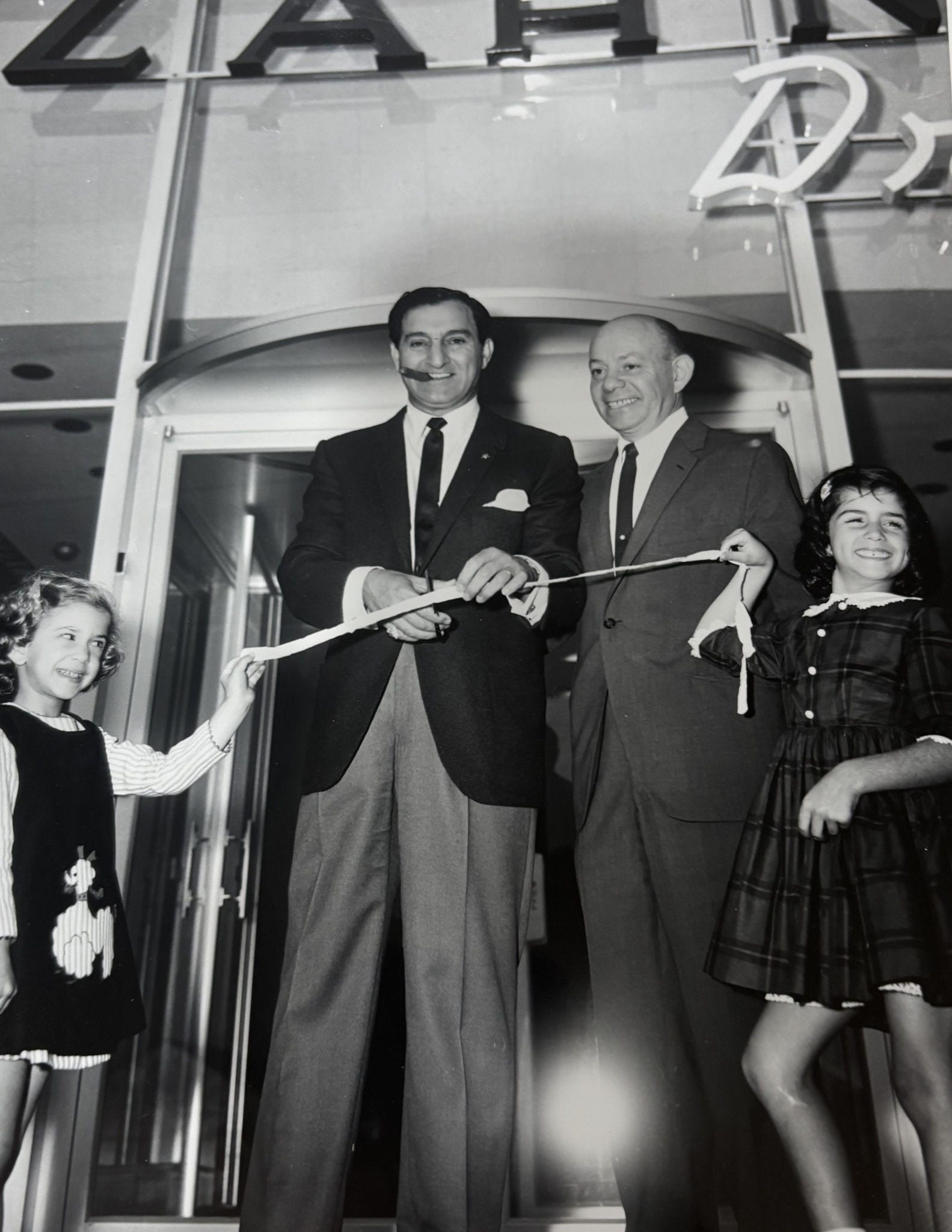 Ginger Siegel, a la derecha, posa con su abuelo, Louis Zahn, y el artista Danny Thomas, en la ceremonia de corte de cinta de la nueva ubicación de Zahn. 