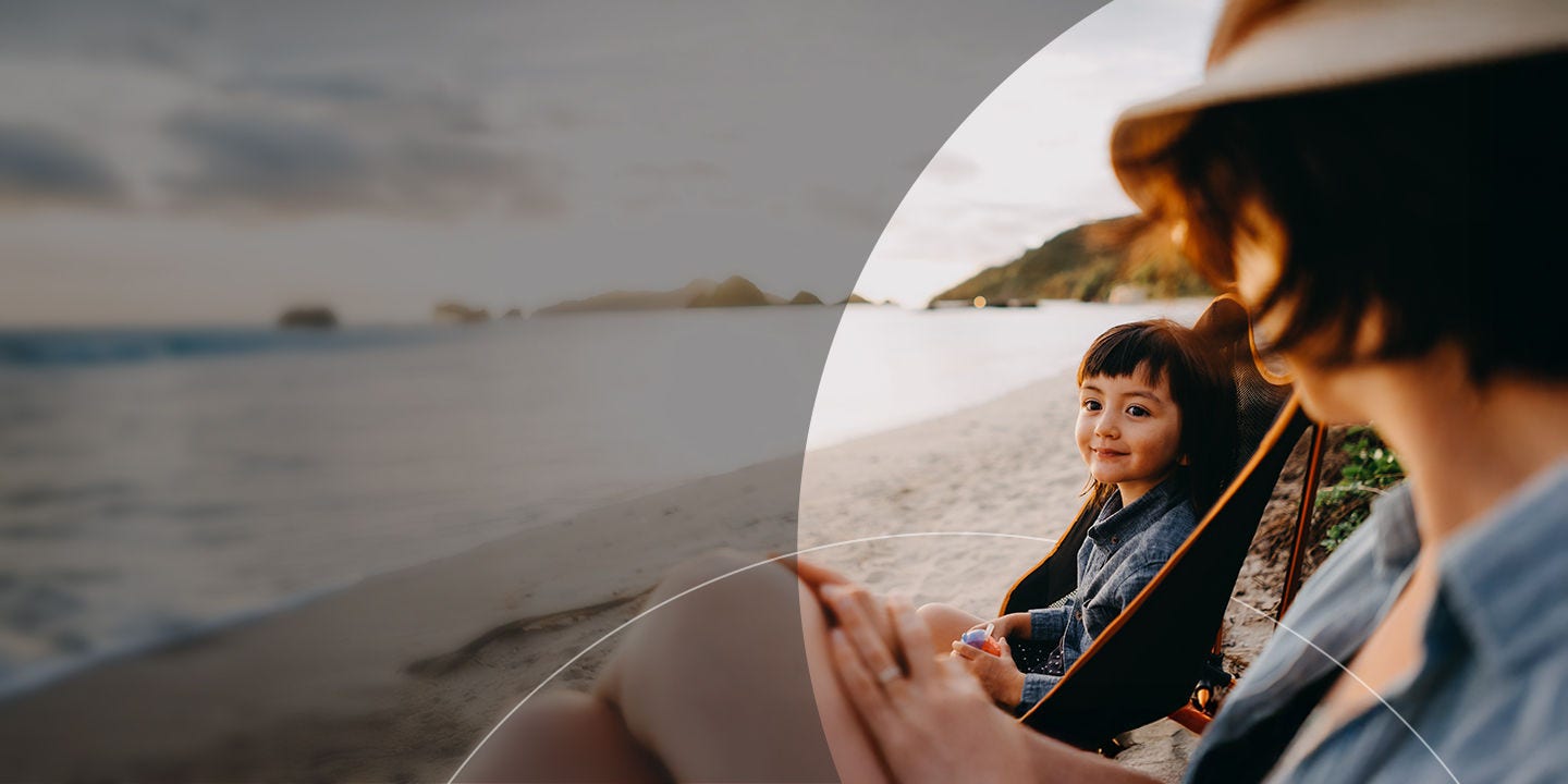 Mother and child sitting on a beach.