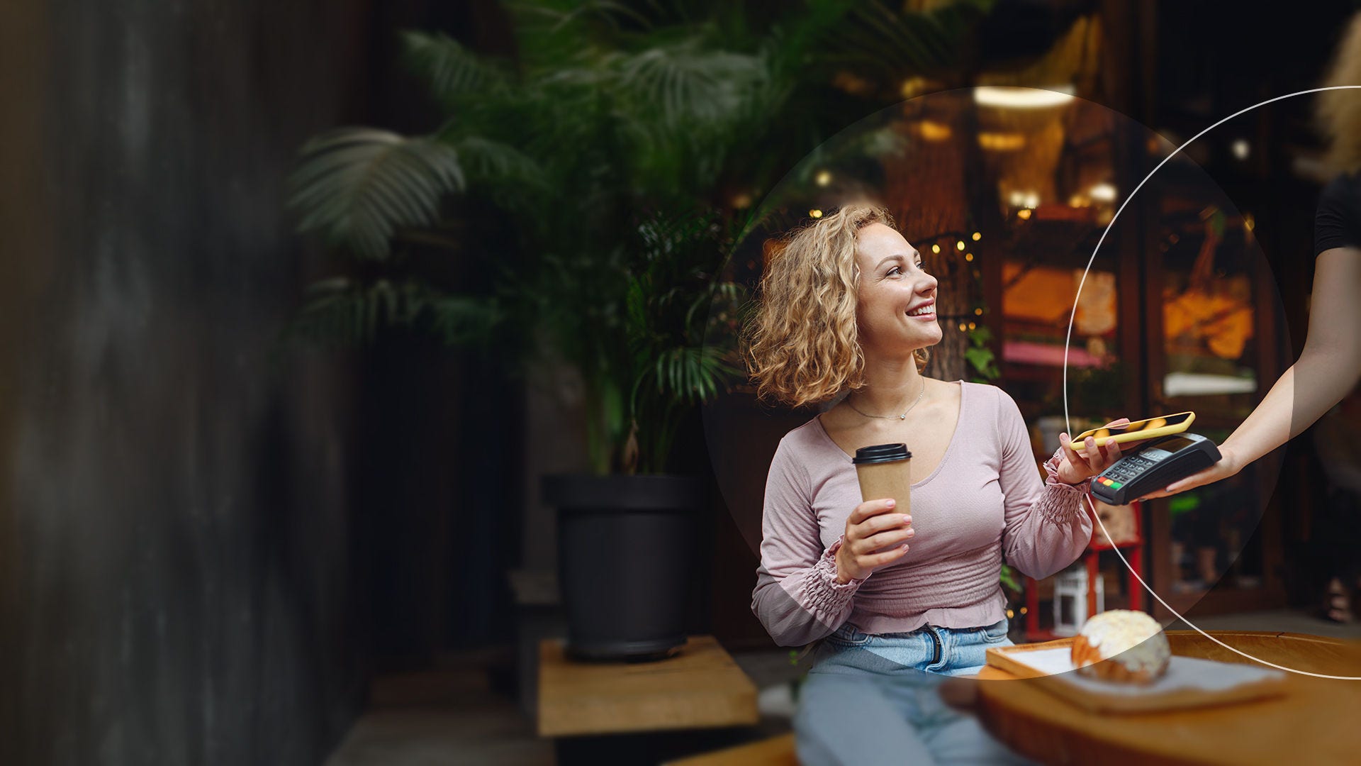 Mujer realizando un pago en una cafetería.