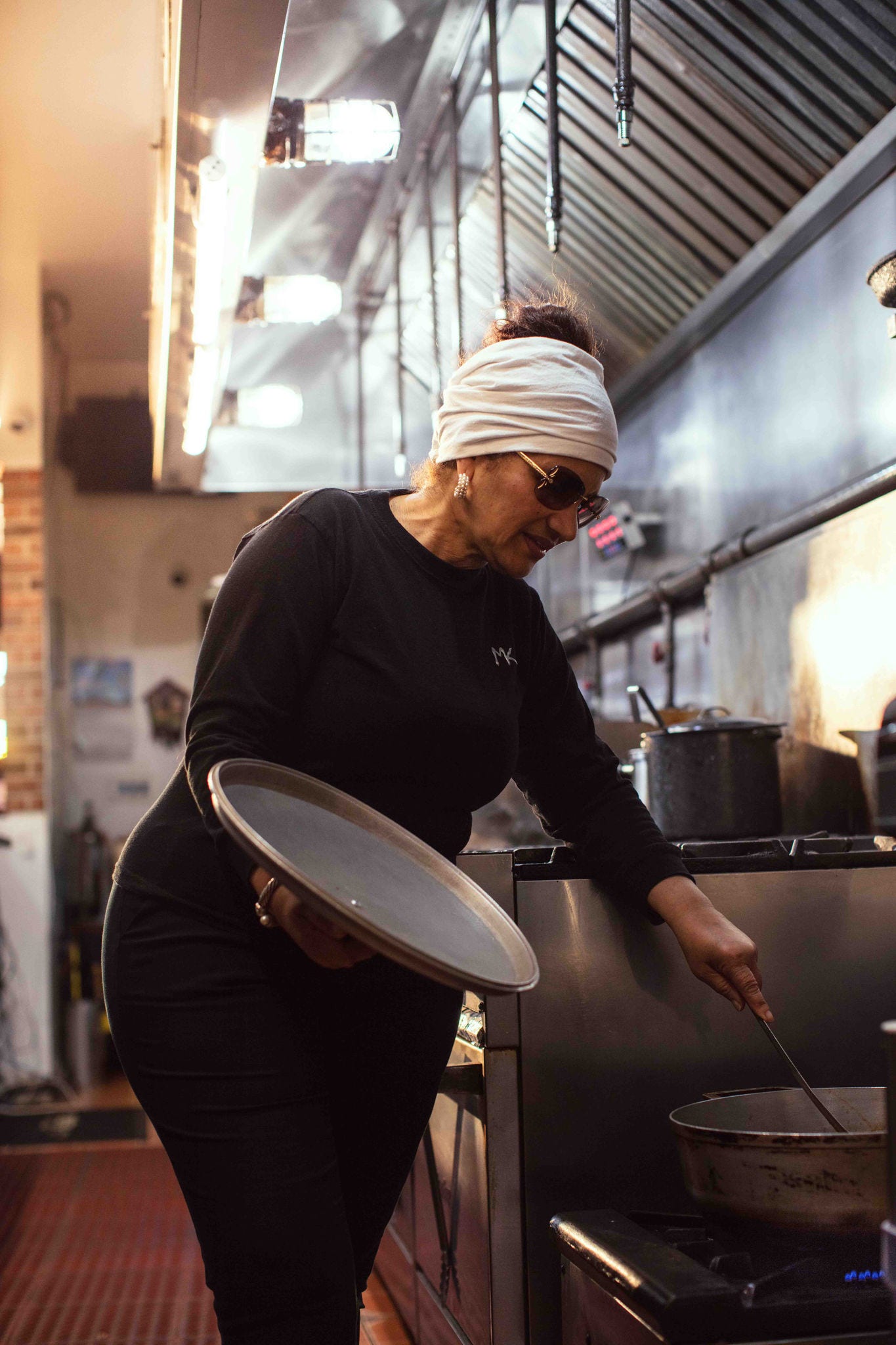 Morena Jorge stirs a pot in Morena's Kitchen and Bar. 