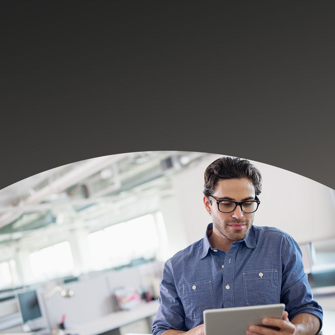 Office worker using tablet to look up latest news and events.