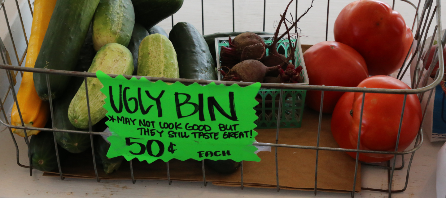 A bin with produce in it labeled "ugly bin." 