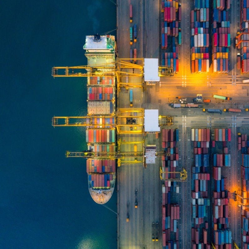 A cargo ship at a dock unloading or loading containers. 