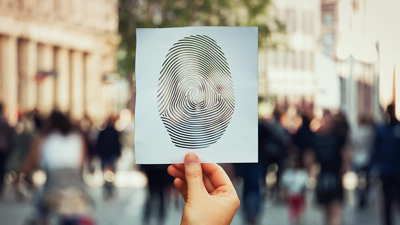 Tenant un papier avec une empreinte digitale parmi la foule pour signaler un vol d’identité.