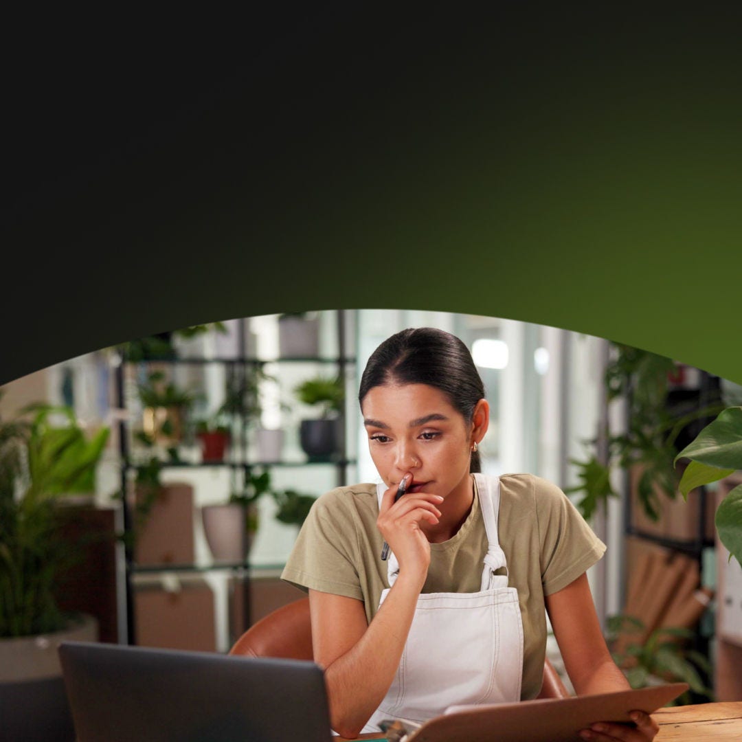 Propietaria de una tienda de plantas haciendo tareas administrativas en su computadora portátil