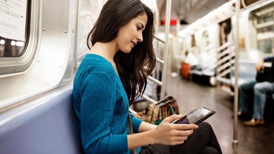 Woman looking at tablet in the subway