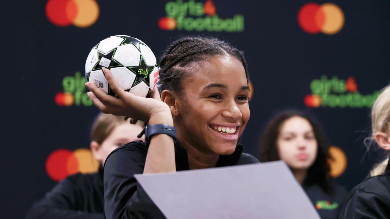 smiling girl holding football ball in a class
