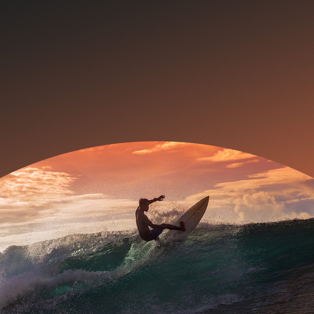 Hombre surfea al amanecer.