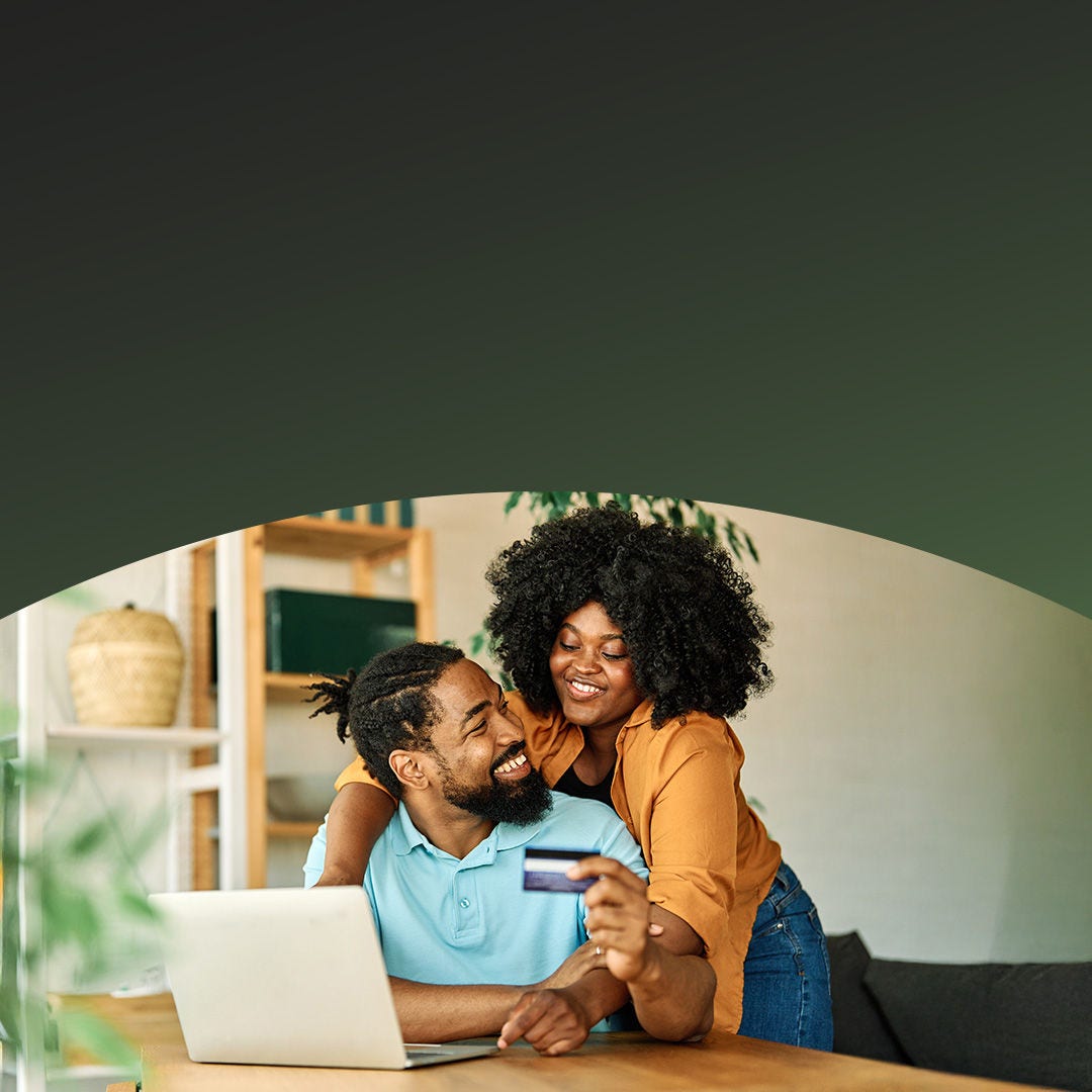 Un couple partageant un moment de joie lors d'un paiement en ligne avec Mastercard sur un ordinateur portable.
