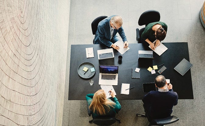 Group of people working at a conference table.