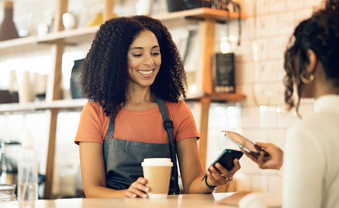 Propietario de una pequeña empresa que usa Tap on Phone para aceptar el pago del cliente. 