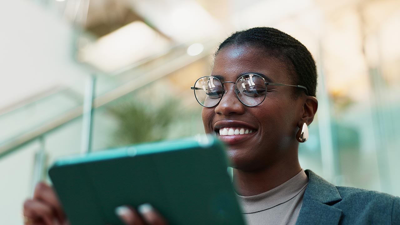 Gros plan d'une jeune femme regardant une tablette.
