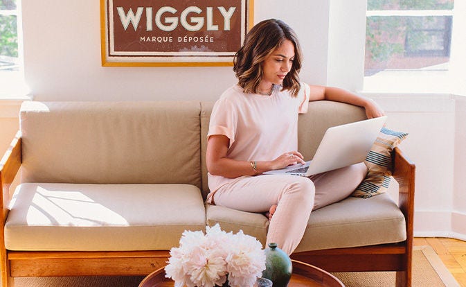 Woman using laptop at home on the sofa