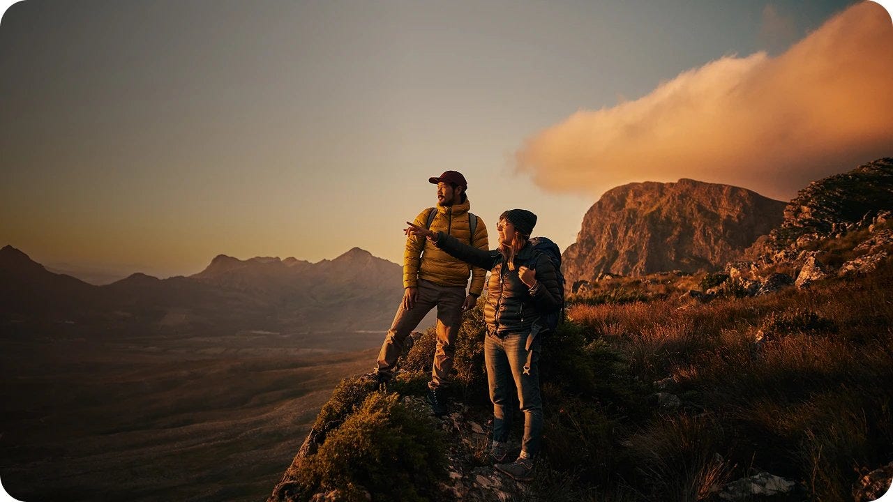 Un par de personas de pie en una montaña