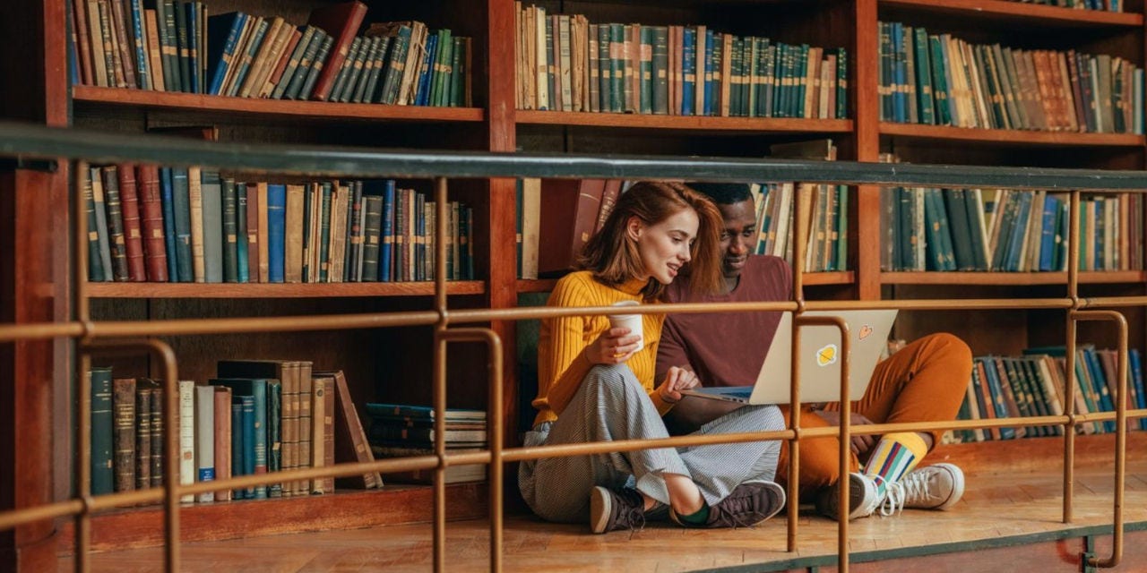 Man and woman looking at computer in a library