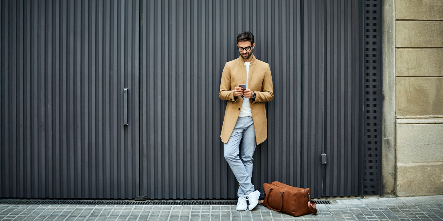 Man with leather bag on smartphone