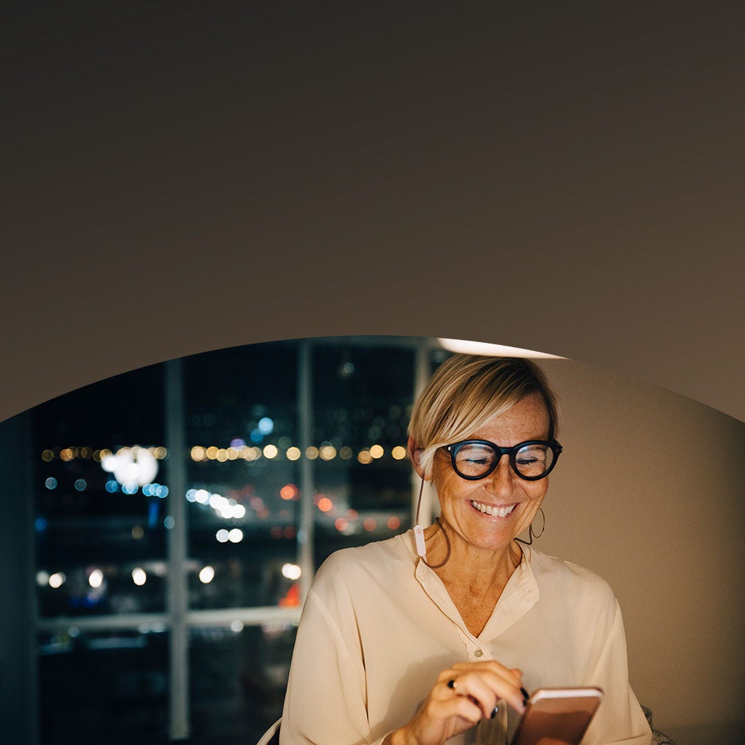 Propriétaire d’une petite entreprise qui sourit en regardant son téléphone.