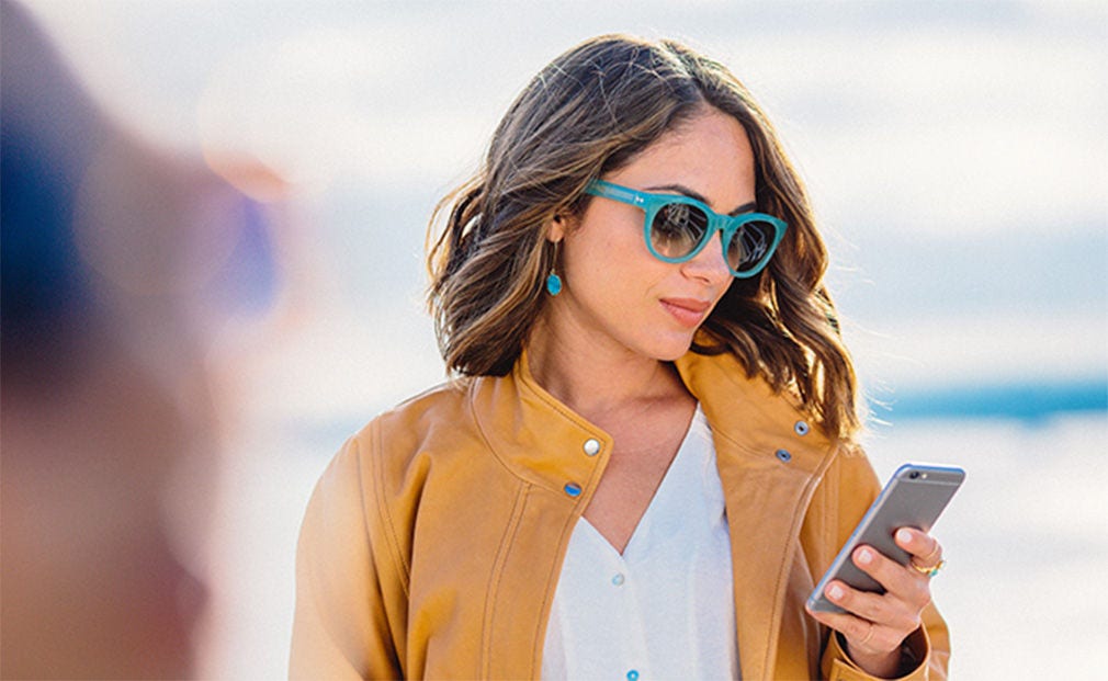 Femme aux lunettes vertes utilisant son téléphone