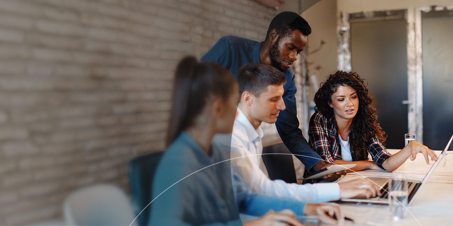 Grupo de personas colaborando alrededor de una computadora portátil.