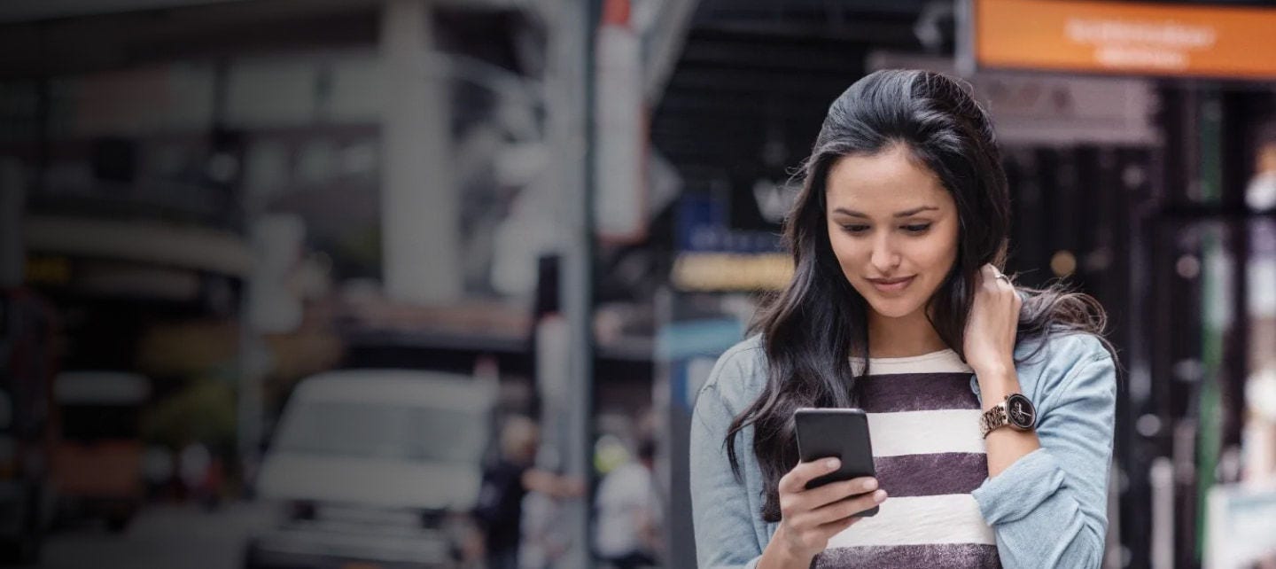 Woman looking at smartphone on city street