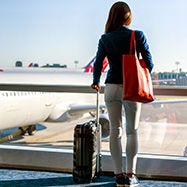 Mujer con equipaje rojo en el aeropuerto.