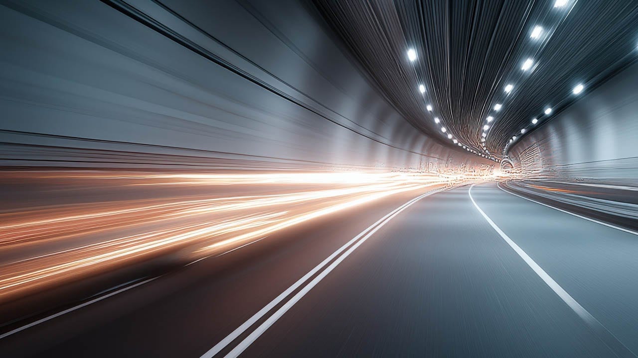 A car drives through a tunnel, surrounded by dynamic light trails illuminating the dark space.