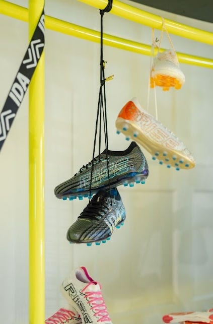 Woman's trainers dangle from a display. 