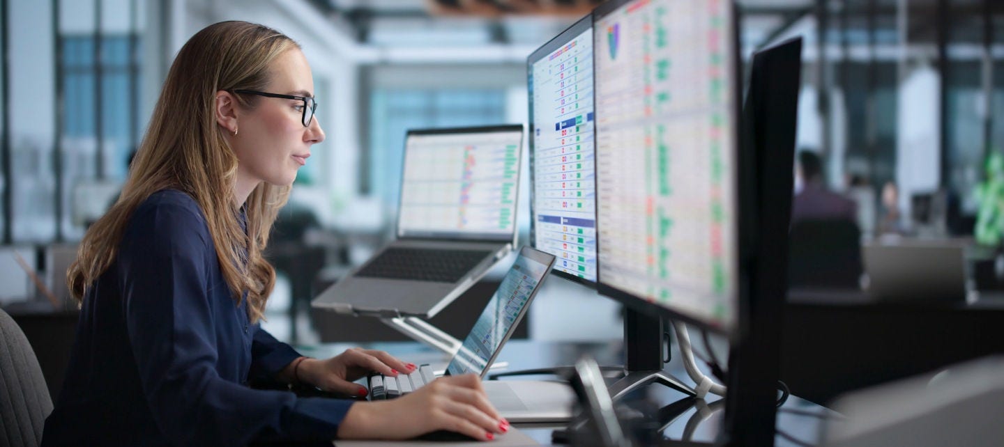 A woman looks at a spreadsheet on a computer in an office. 
