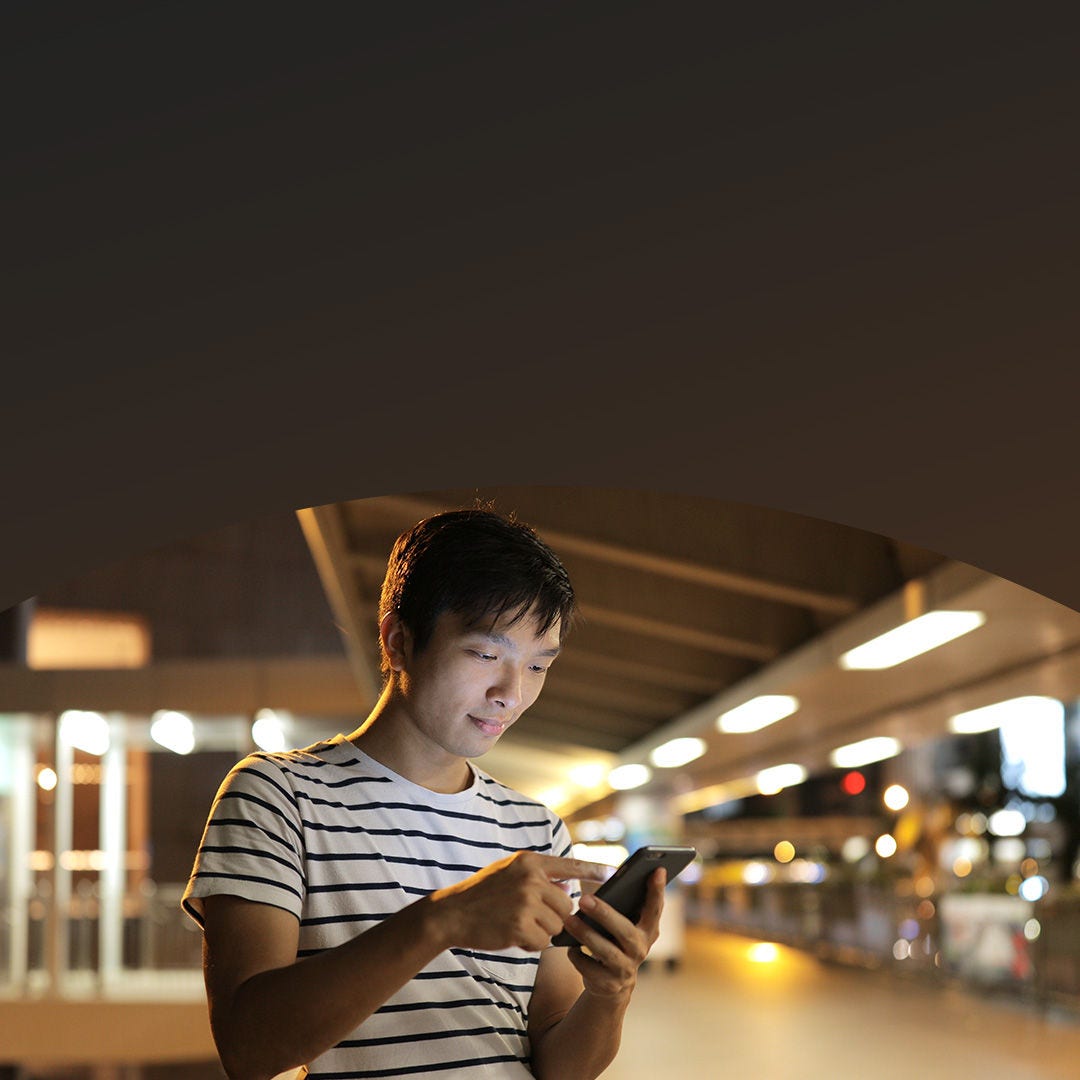 hombre usando el teléfono al aire libre por la noche.