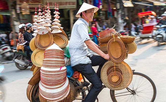 Vendedor de bicicletas recorriendo una calle de Asia.